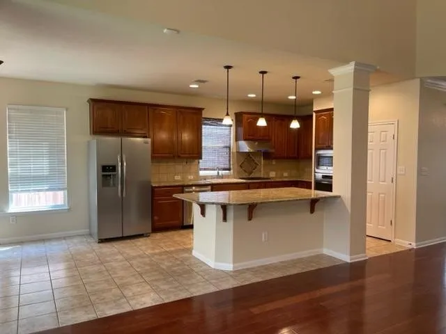 a kitchen with stainless steel appliances granite countertop a refrigerator a sink and a stove