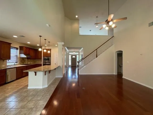 a kitchen with stainless steel appliances kitchen island granite countertop a refrigerator a sink and a stove