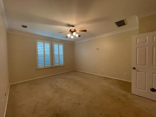 an empty room with windows and ceiling fan