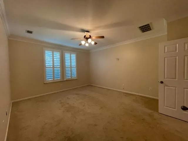 an empty room with windows and ceiling fan