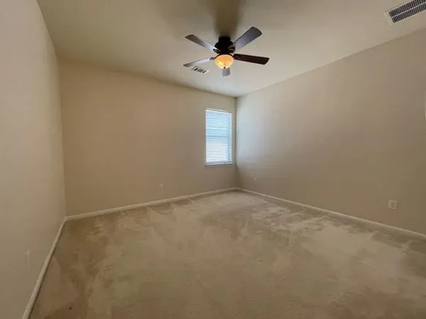 an empty room with a window and a fan