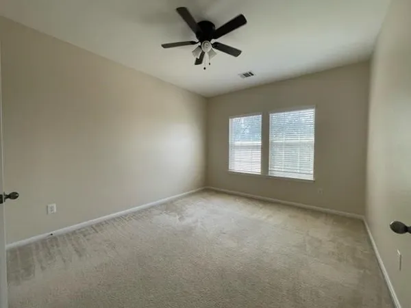 an empty room with a window and a ceiling fan