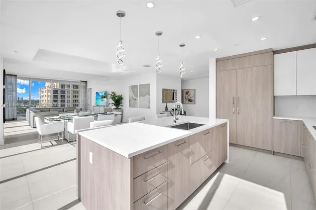 a dining room with stainless steel appliances kitchen island granite countertop a dining table chairs and view living room