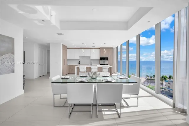 a dining area with a table chairs and a kitchen view
