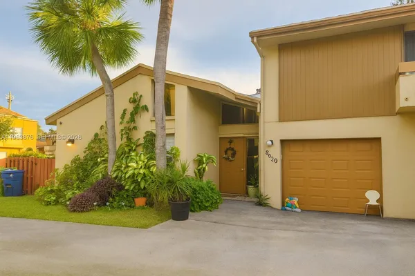 a front view of a house with a garden and yard