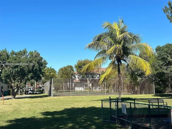 a view of a swimming pool with a garden and palm trees