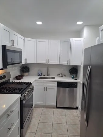 a kitchen with stainless steel appliances granite countertop a stove a refrigerator and a sink