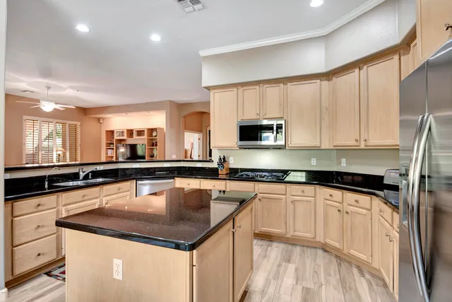 a kitchen with granite countertop white cabinets and stainless steel appliances