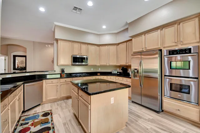 a kitchen with granite countertop a table chairs microwave and cabinets