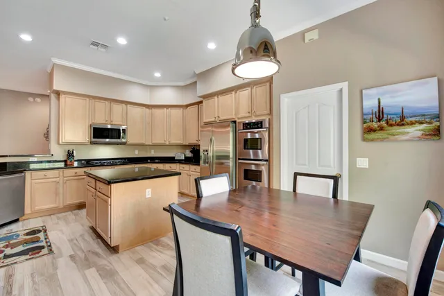a kitchen with stainless steel appliances granite countertop a sink a stove and a wooden floors