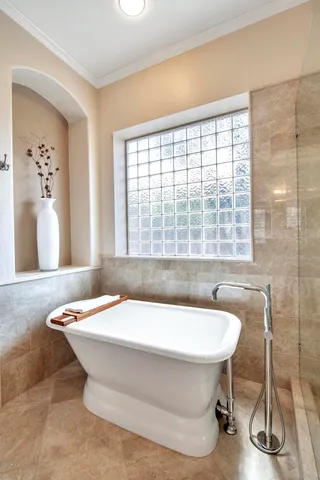 a spacious bathroom with a granite countertop sink a mirror and a bathtub