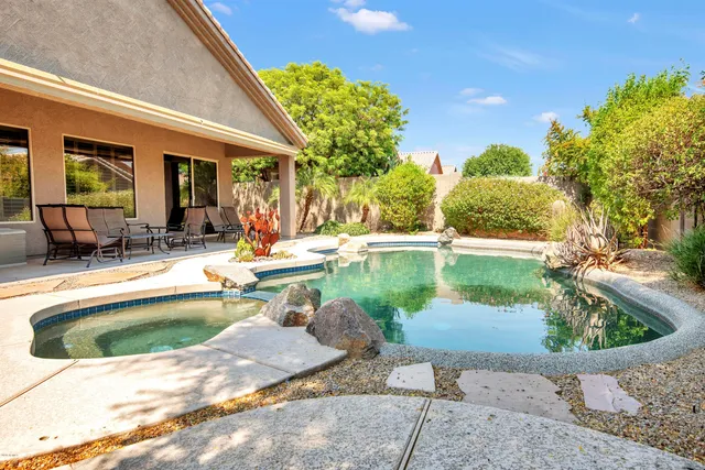 a view of a swimming pool with a patio and plants