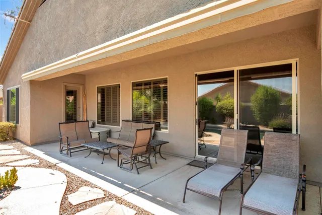 a view of a patio with table and chairs potted plants with wooden floor and fence