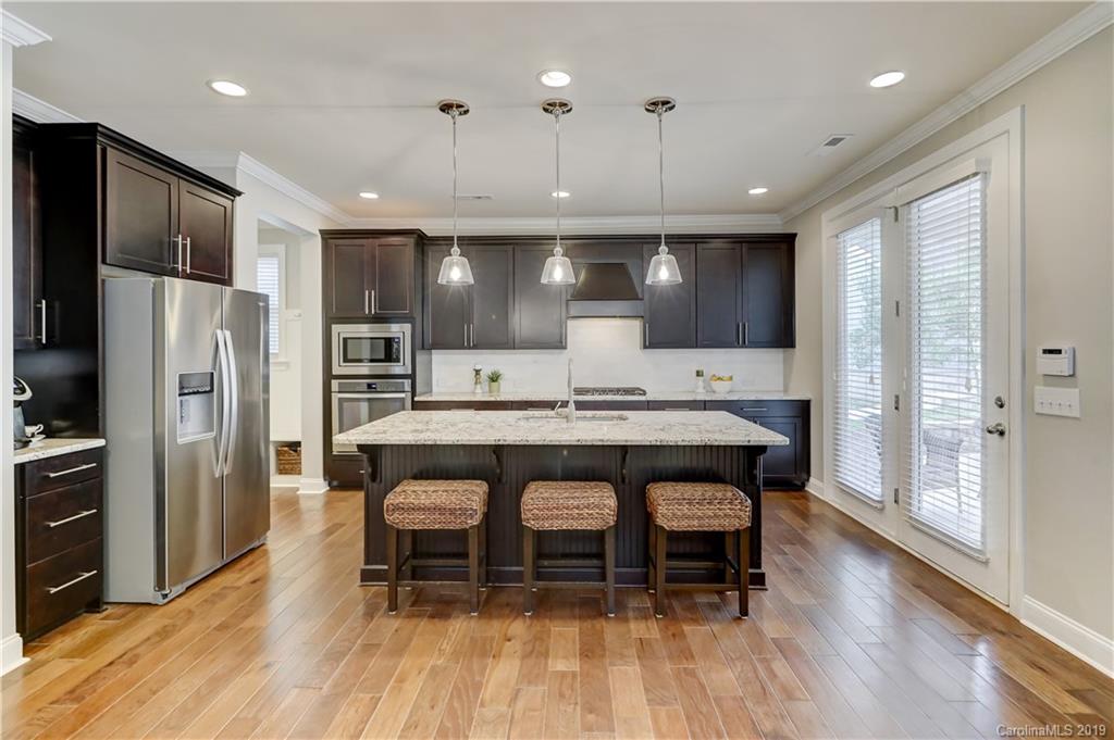 108 Helton Lane Fort Mill, SC 29708 - Photo 12 of 48 a kitchen with stainless steel appliances granite countertop a table chairs refrigerator and microwave