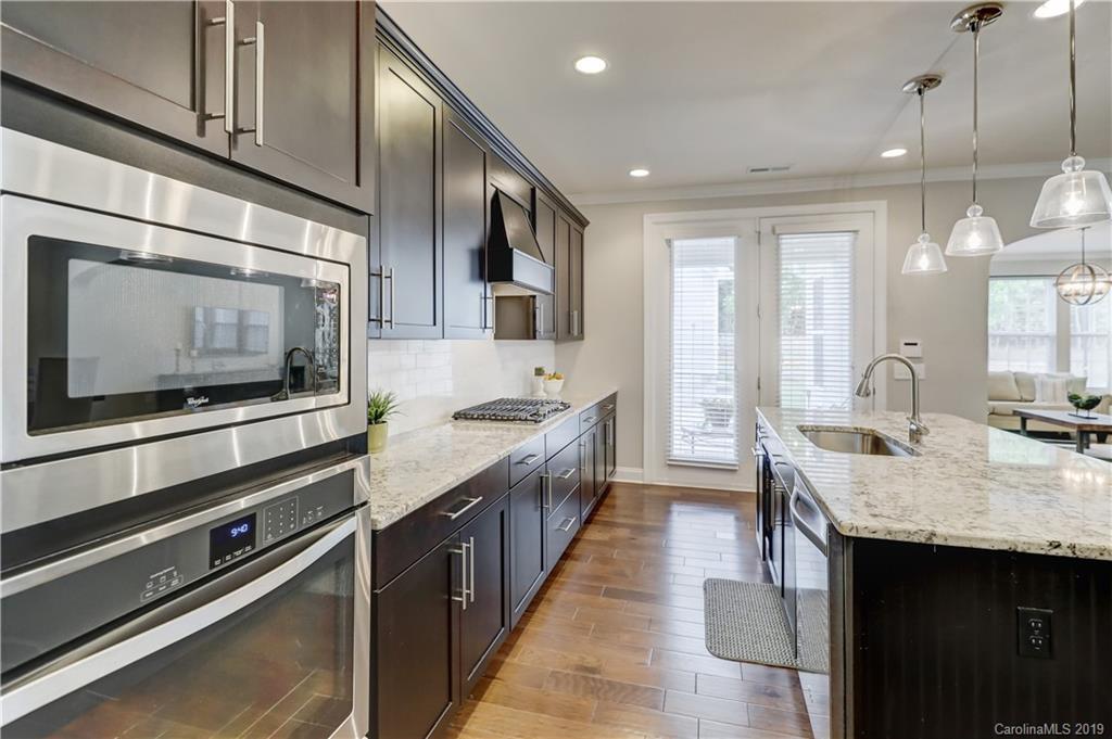 108 Helton Lane Fort Mill, SC 29708 - Photo 18 of 48 a kitchen with stainless steel appliances kitchen island granite countertop a stove a sink and a microwave