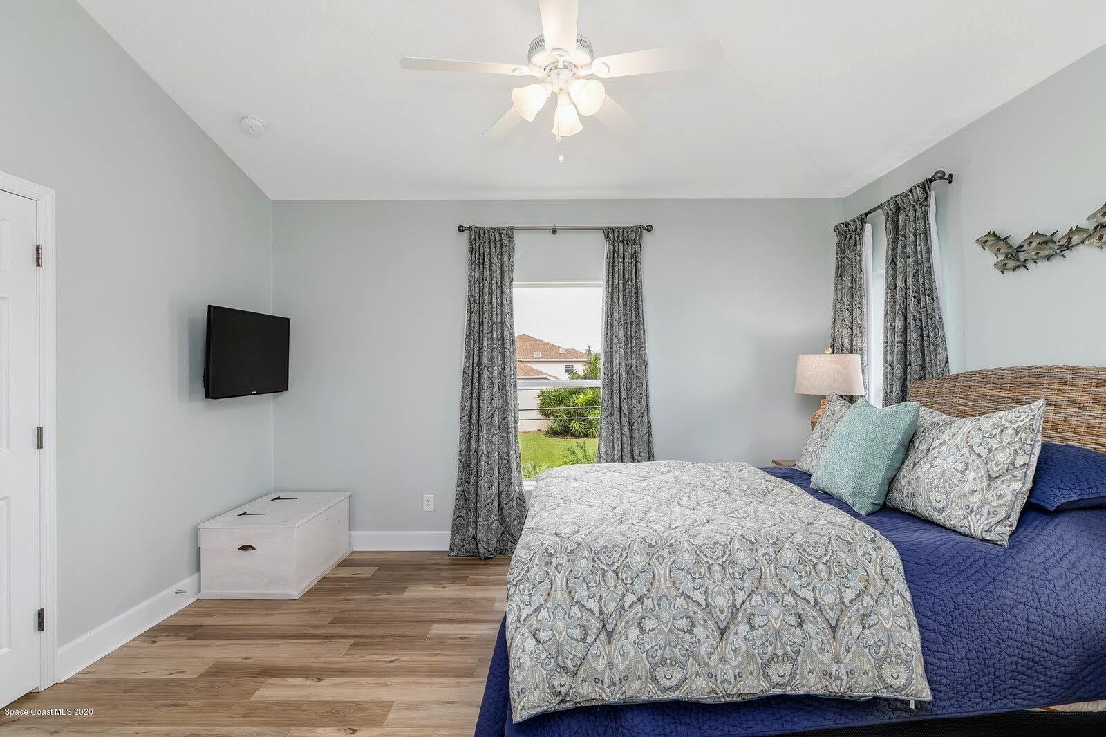 230 Richards Road Melbourne Beach, FL 32951 - Photo 14 of 42 a bedroom with a bed and flat screen tv