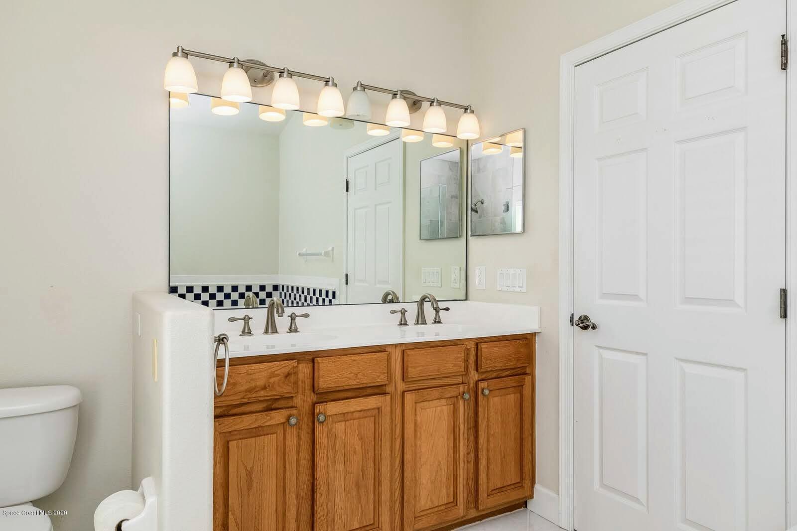 230 Richards Road Melbourne Beach, FL 32951 - Photo 16 of 42 a bathroom with a sink a toilet and mirror