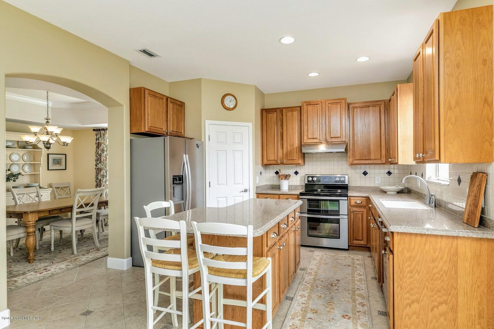 230 Richards Road Melbourne Beach, FL 32951 - Photo 6 of 42 a kitchen with stainless steel appliances granite countertop a sink stove and refrigerator