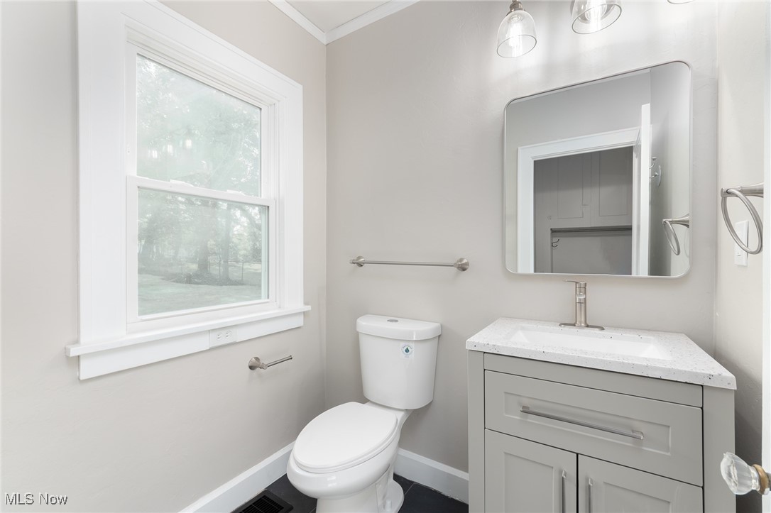 3459 Helen Road Shaker Heights, OH 44122 - Photo 14 of 29 Half bathroom with visible vents, baseboards, ornamental molding, toilet, and vanity
