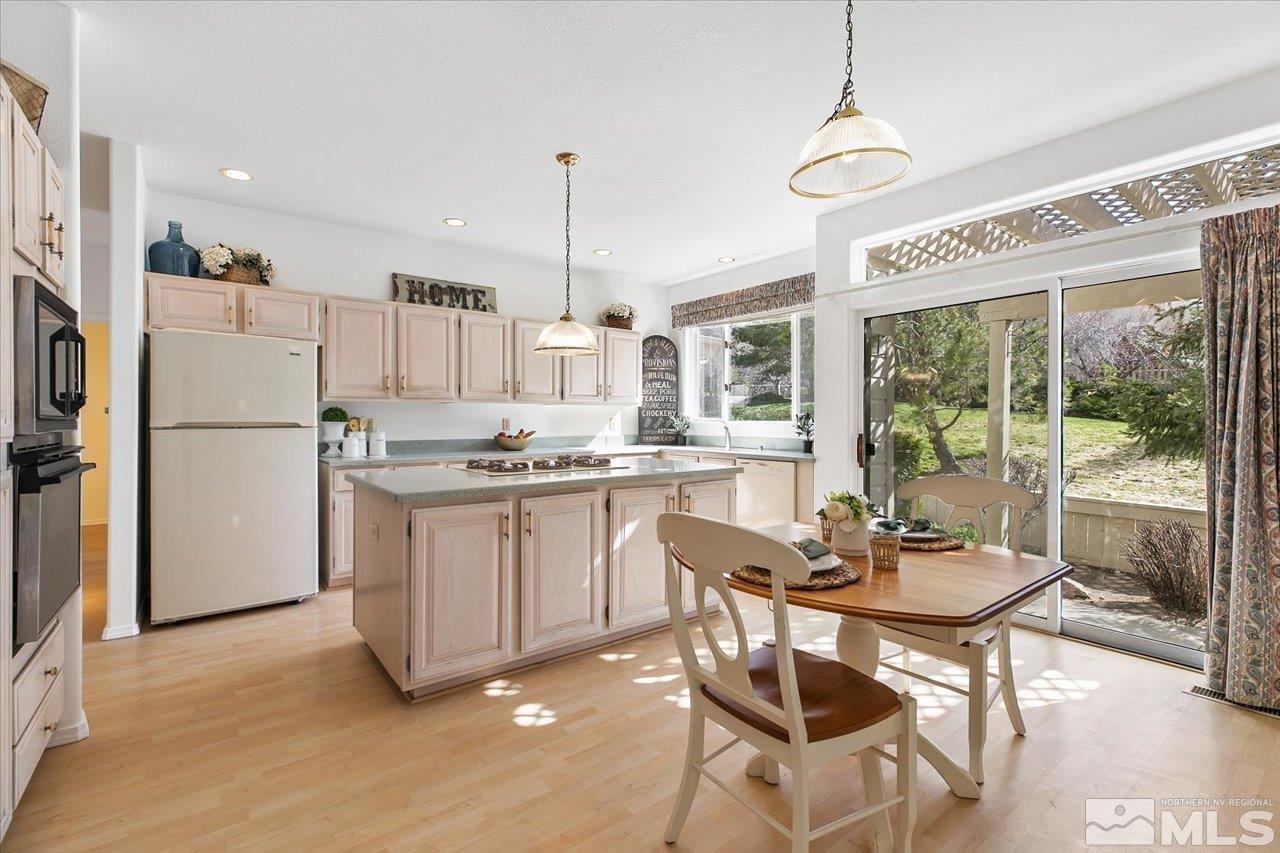 4035 Caughlin Creek Road Reno, NV 89519 - Photo 12 of 40 a kitchen with stainless steel appliances kitchen island granite countertop a refrigerator a oven a stove and a dining table with wooden floor
