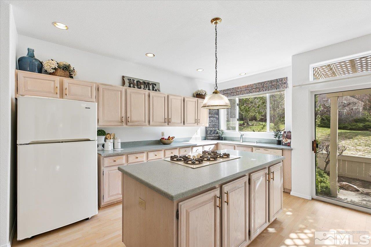 4035 Caughlin Creek Road Reno, NV 89519 - Photo 14 of 40 a kitchen with a stove a refrigerator a sink and a dining table with wooden floor