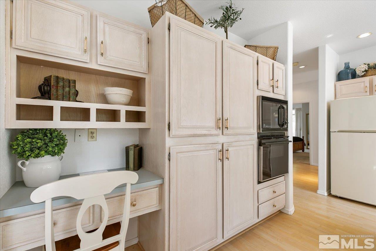 4035 Caughlin Creek Road Reno, NV 89519 - Photo 15 of 40 a kitchen with stainless steel appliances white cabinets and wooden floor