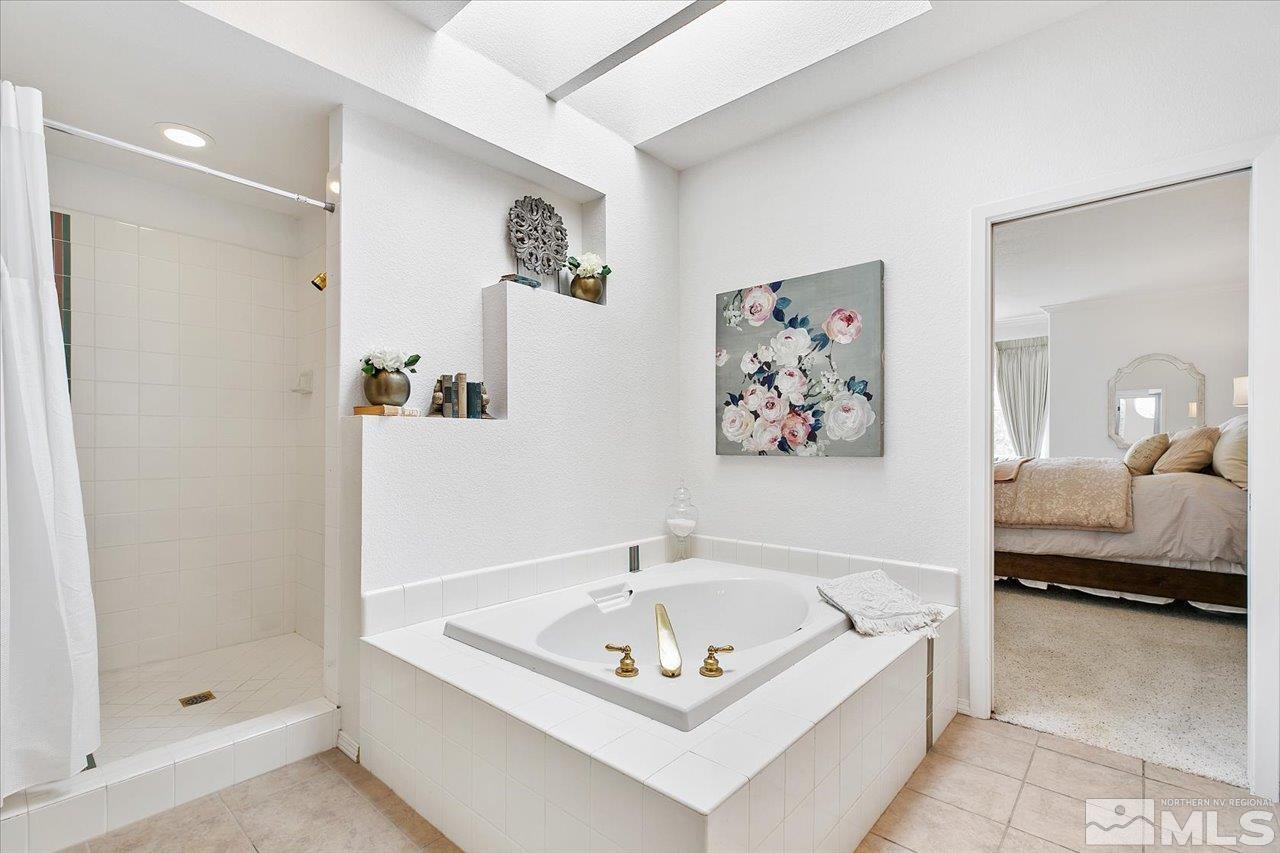 4035 Caughlin Creek Road Reno, NV 89519 - Photo 22 of 40 a bathroom with a tub a sink and a shower