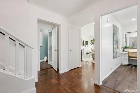 a view of a hallway with bathroom and wooden floor