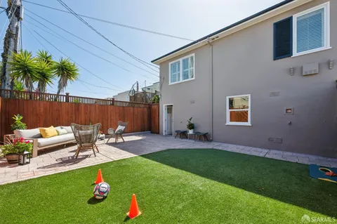 a view of a patio with table and chairs potted plants and wooden fence