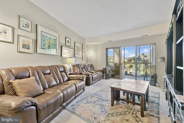 a living room with furniture a large window and a dining table