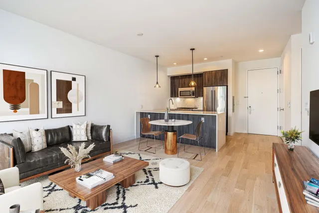 a living room with furniture and kitchen view