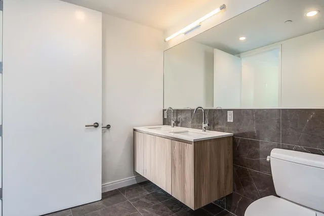 a bathroom with a toilet a sink and mirror