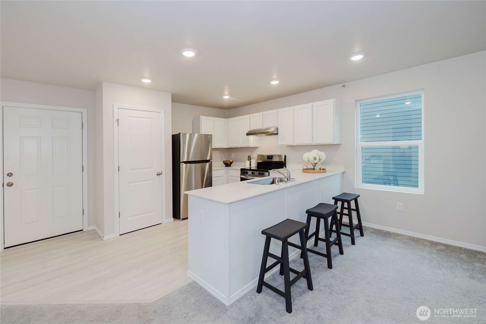 240 Northeast Olympic Ridge Belfair, WA 98528 - Photo 11 of 28 a kitchen with kitchen island white cabinets and stainless steel appliances