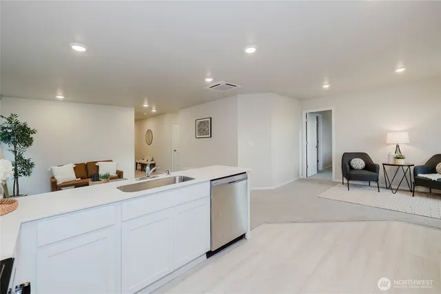 a kitchen with a refrigerator a microwave oven a sink and a dining table with wooden floor