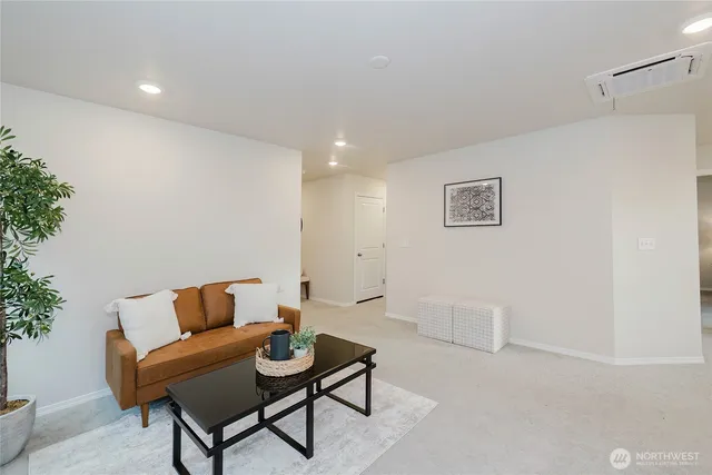 a living room with furniture and a dining table with kitchen view