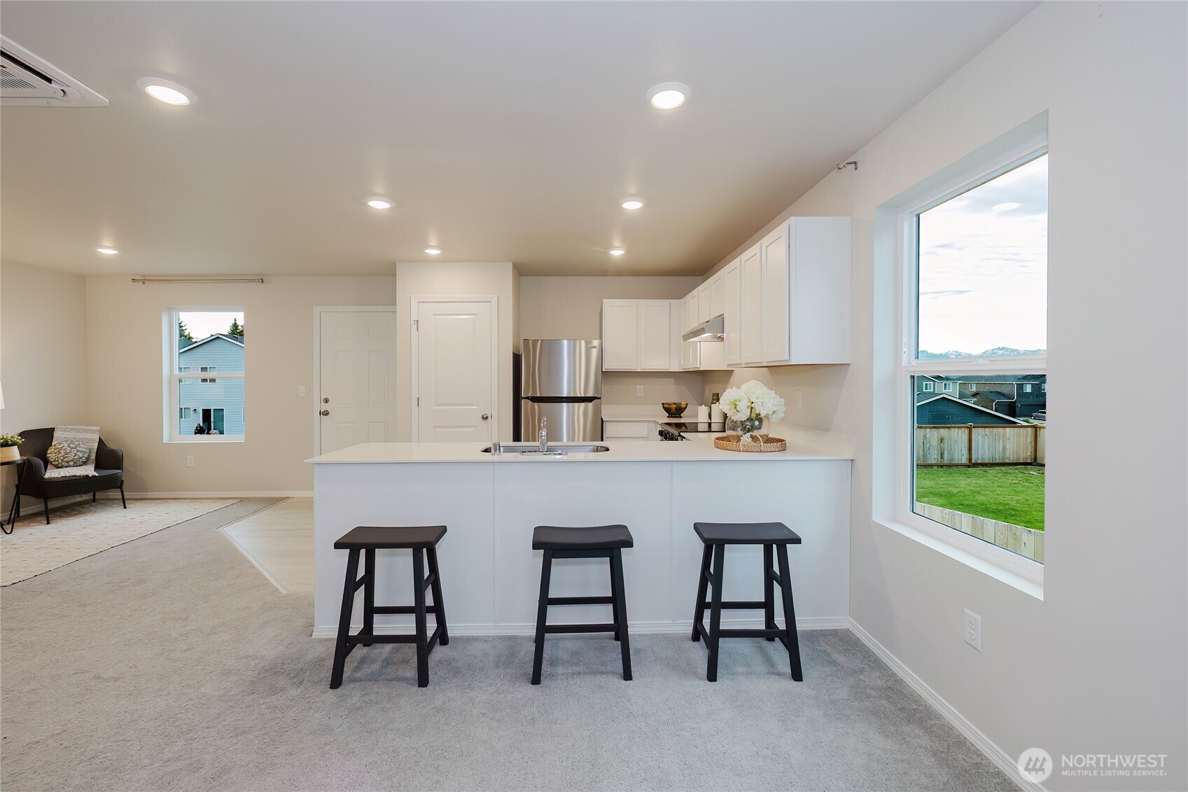 240 Northeast Olympic Ridge Belfair, WA 98528 - Photo 10 of 28 a kitchen with stainless steel appliances granite countertop a table chairs sink and cabinets