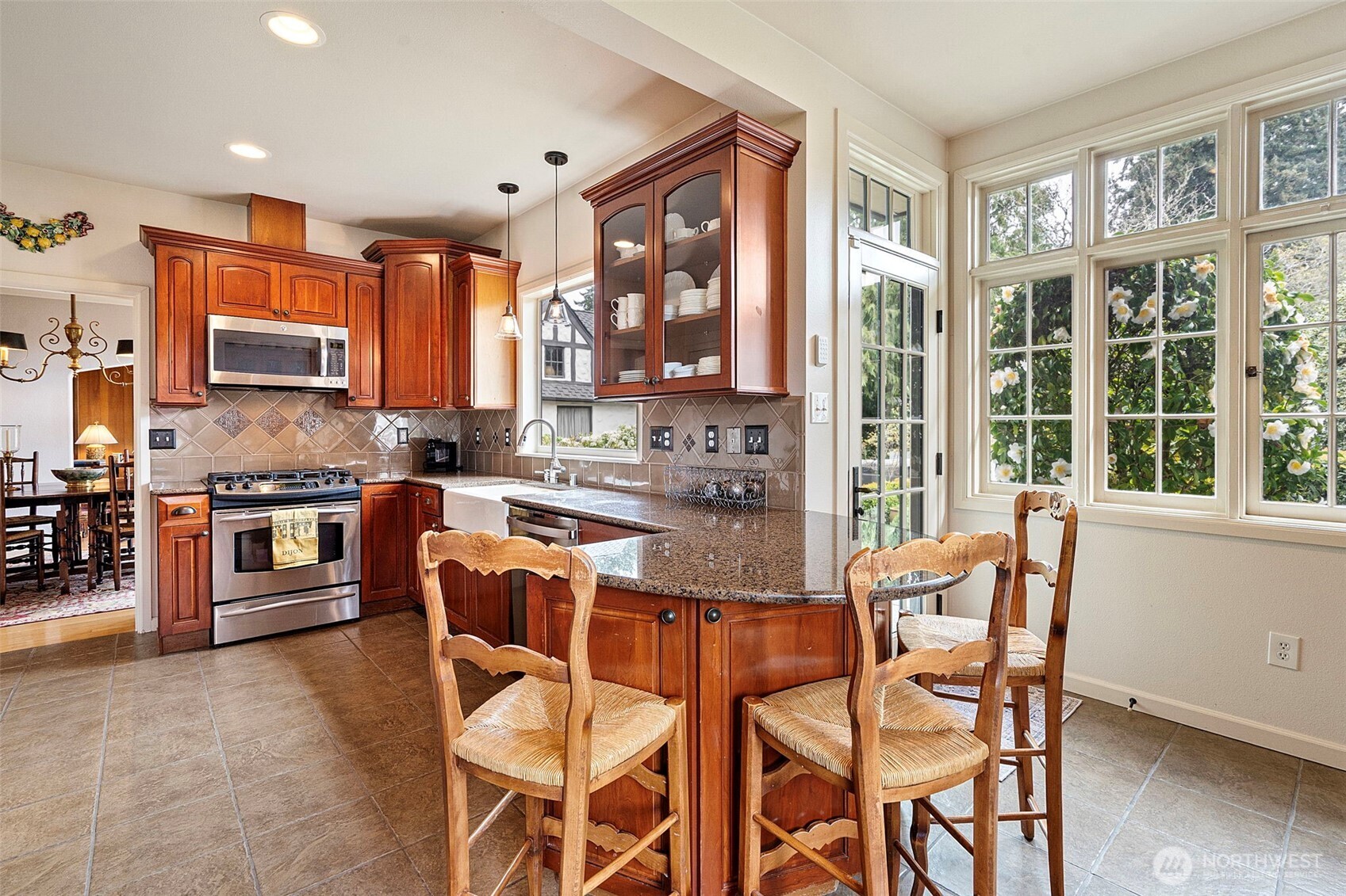 659 Alta Vista Place Fircrest, WA 98466 - Photo 10 of 40 a kitchen with stainless steel appliances granite countertop a stove top oven a sink a dining table and chairs
