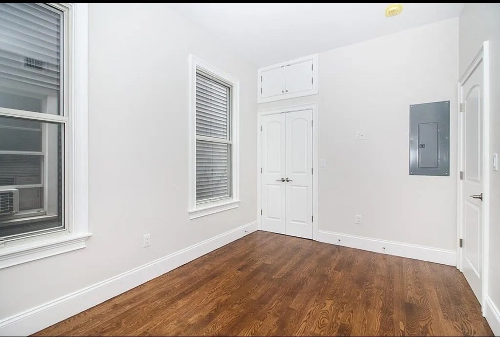 249 Lexington Street, Unit 2 Boston, MA 02128 - Photo 3 of 19 an empty room with wooden floor and windows