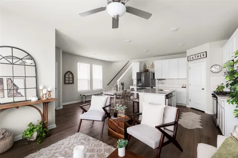 a living room with furniture a dining table and a potted plant