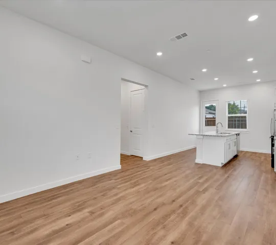 a view of kitchen and hall with wooden floor