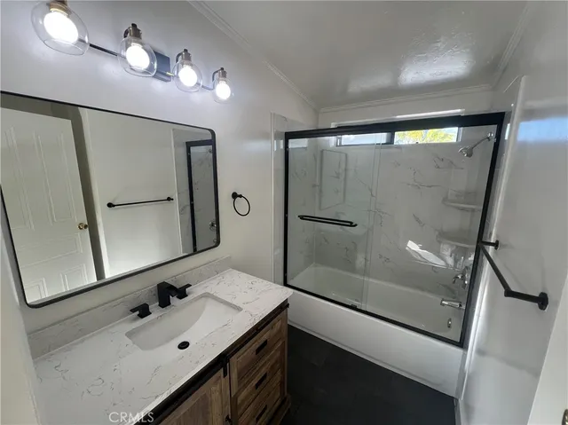 a bathroom with a sink a mirror a vanity and shower