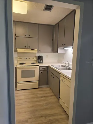 a kitchen with a stove white cabinets and a refrigerator