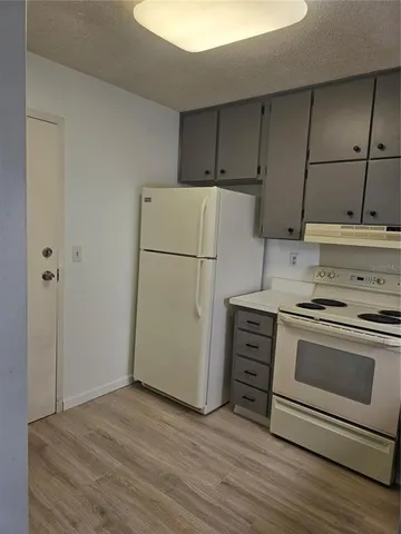 a kitchen with cabinets appliances and wooden floor