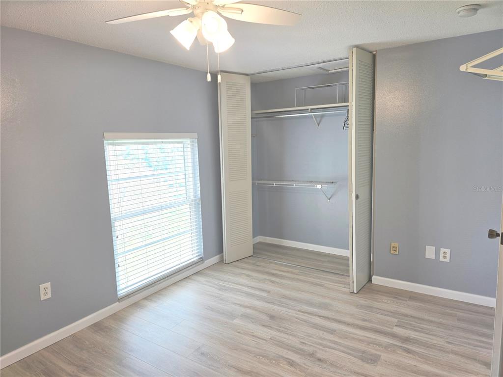 2700 Bayshore Boulevard, Unit 1302 Dunedin, FL 34698 - Photo 19 of 40 an empty room with wooden floor cabinet and windows