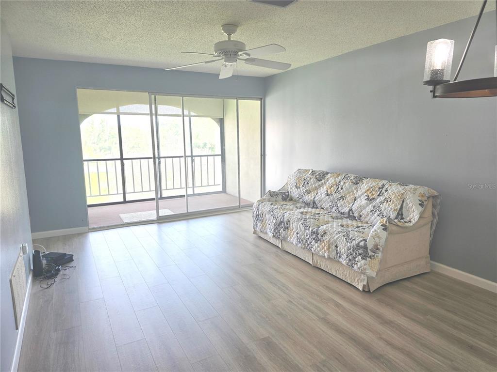 2700 Bayshore Boulevard, Unit 1302 Dunedin, FL 34698 - Photo 9 of 40 wooden floor in an empty room with a window