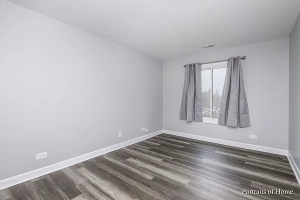a view of wooden floor and windows in a room