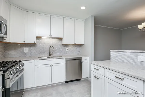 a kitchen with cabinets appliances a sink and a counter top space