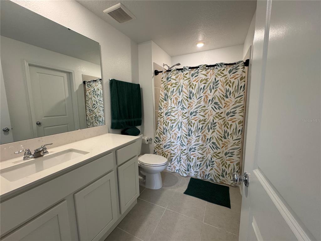2405 Bluestone Road Haines City, FL 33844 - Photo 12 of 17 a bathroom with a granite countertop sink toilet and shower