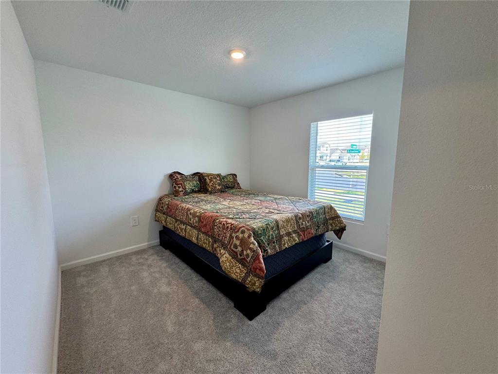 2405 Bluestone Road Haines City, FL 33844 - Photo 13 of 17 a bedroom with a bed and a window