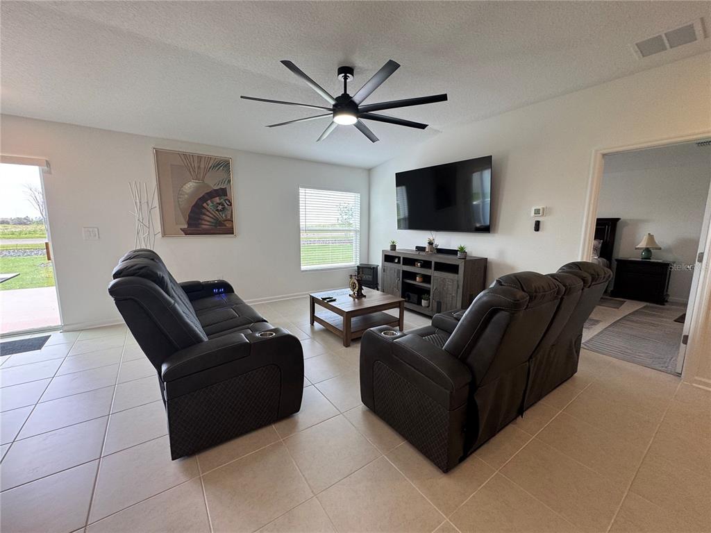 2405 Bluestone Road Haines City, FL 33844 - Photo 5 of 17 a living room with furniture and a flat screen tv